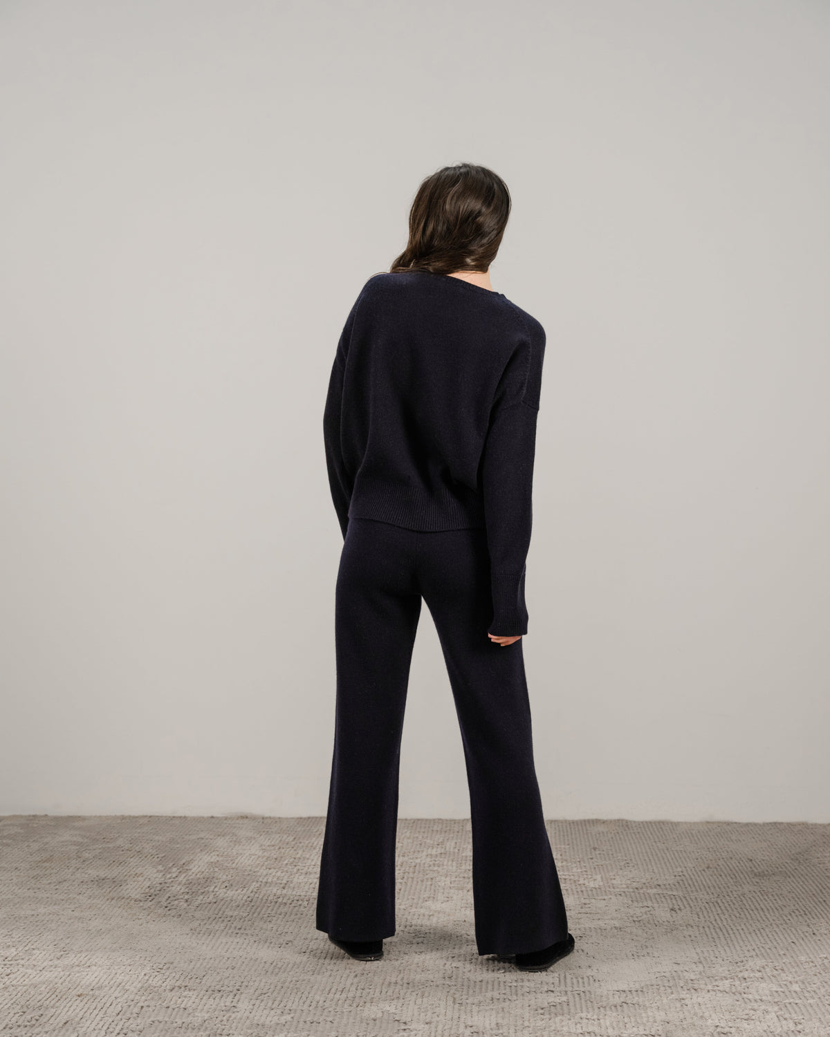 Back view of a mannequin portant navy cashmere mix pull col rond with pantalon large assorti
