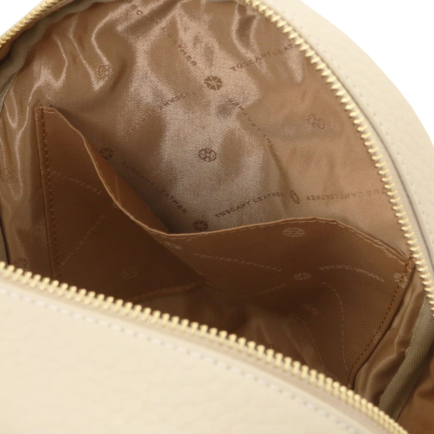 Inside view of Arco leather backpack showing a zip pocket and logo patterned tan lining
