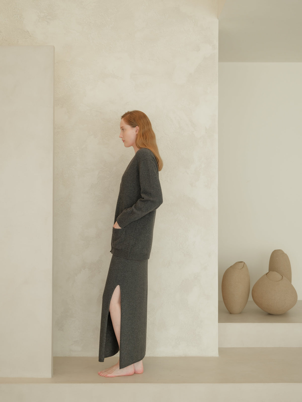 Seitenansicht of a Frau trägt a dark gray cashmere blend high-waist long knit skirt with a side slit