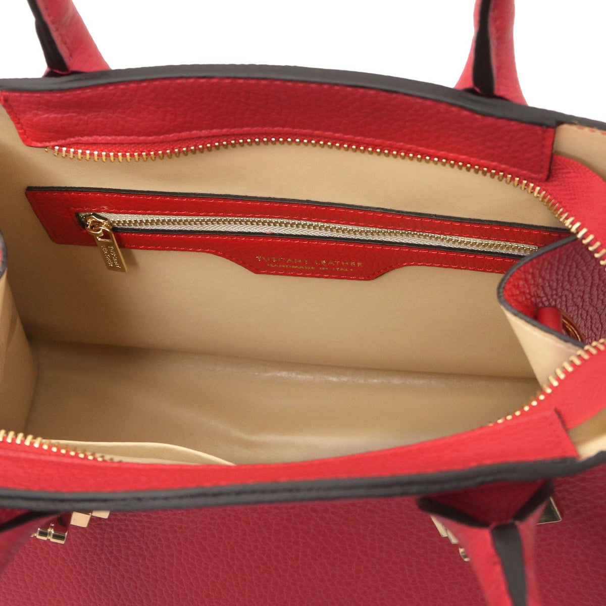 Interior of red Coccola leather tote showing beige lining and gold zip pocket