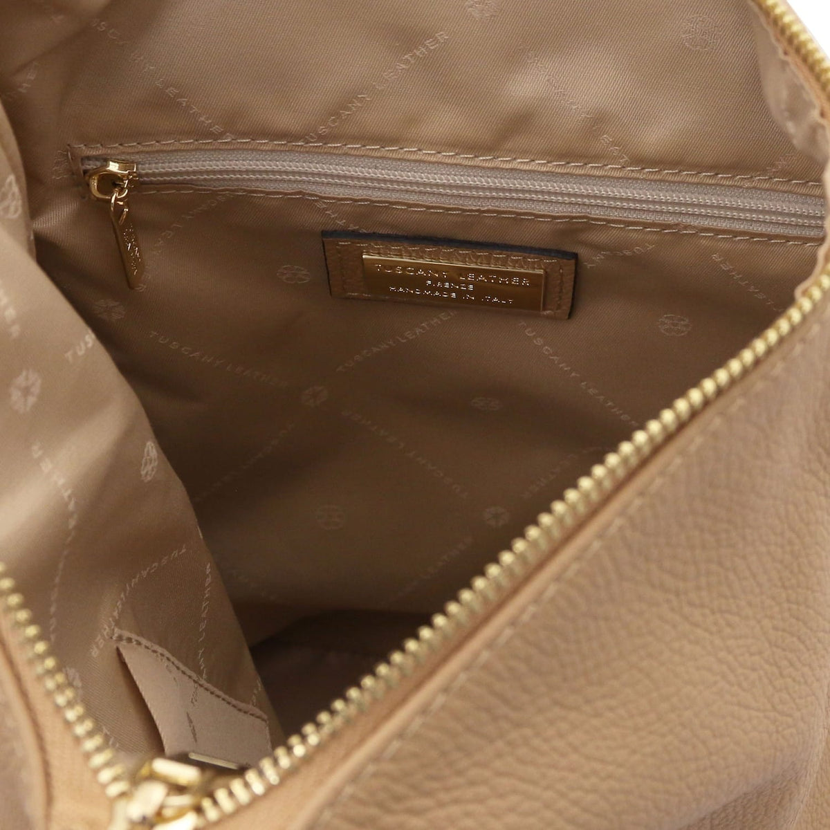 Interior view of the Dublin soft Italian leather backpack showing a zip pocket, tan lining, and a branded label inside