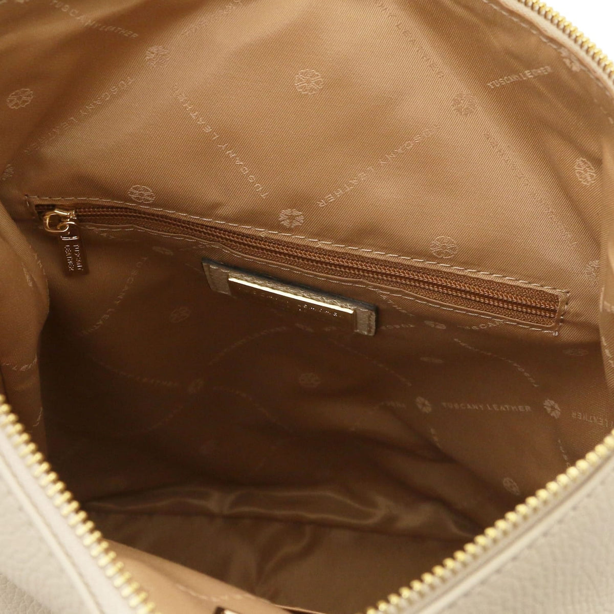 Open interior of Dublin backpack with brown lining and a zippered pocket along the side