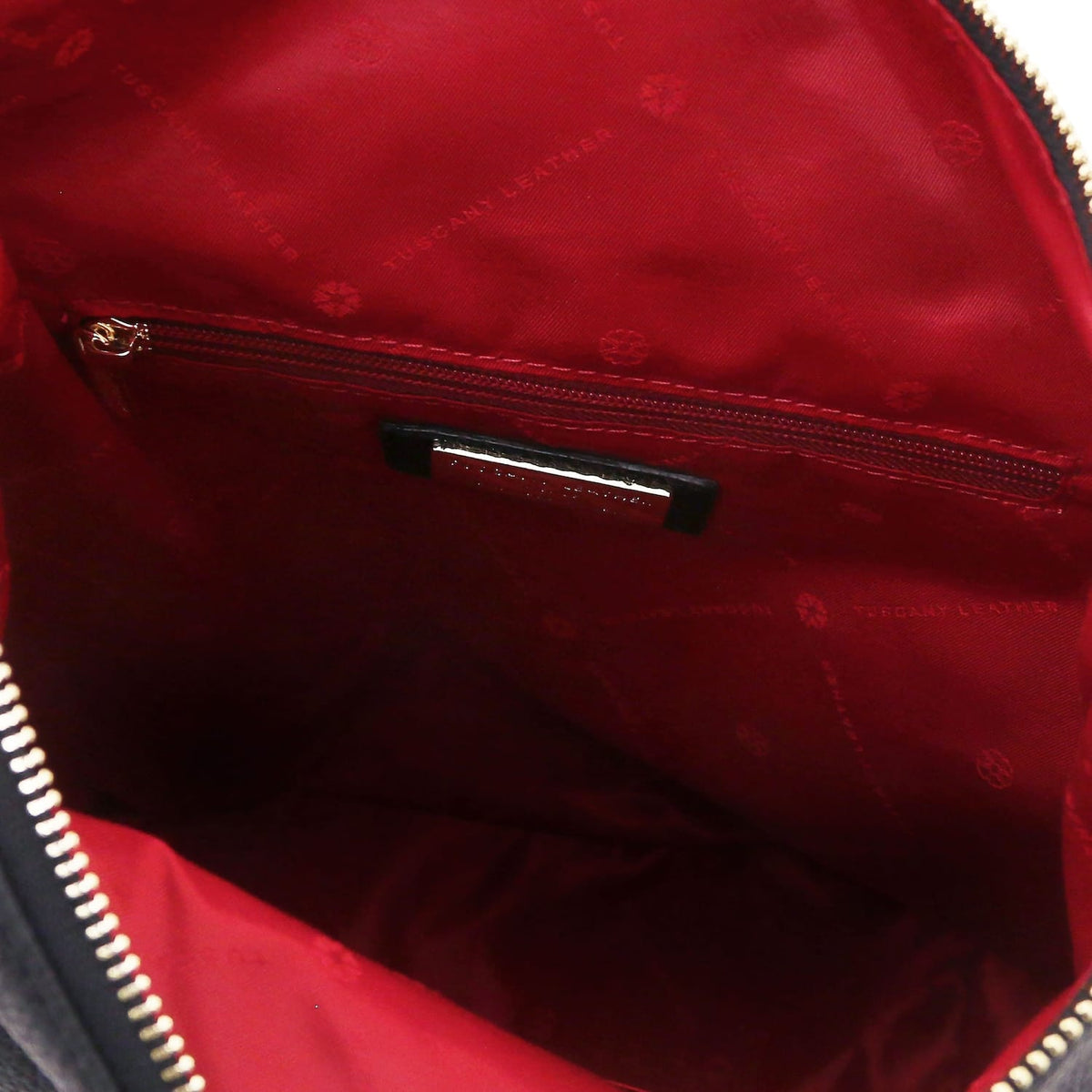 Red interior of the Dublin backpack with a zipped pocket and logo patterned lining