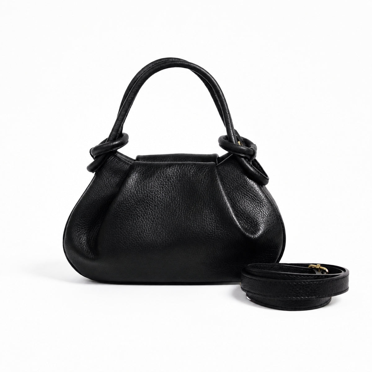 A black pebbled leather handbag with a top handle and matching detachable strap, photographed on a clean white background.