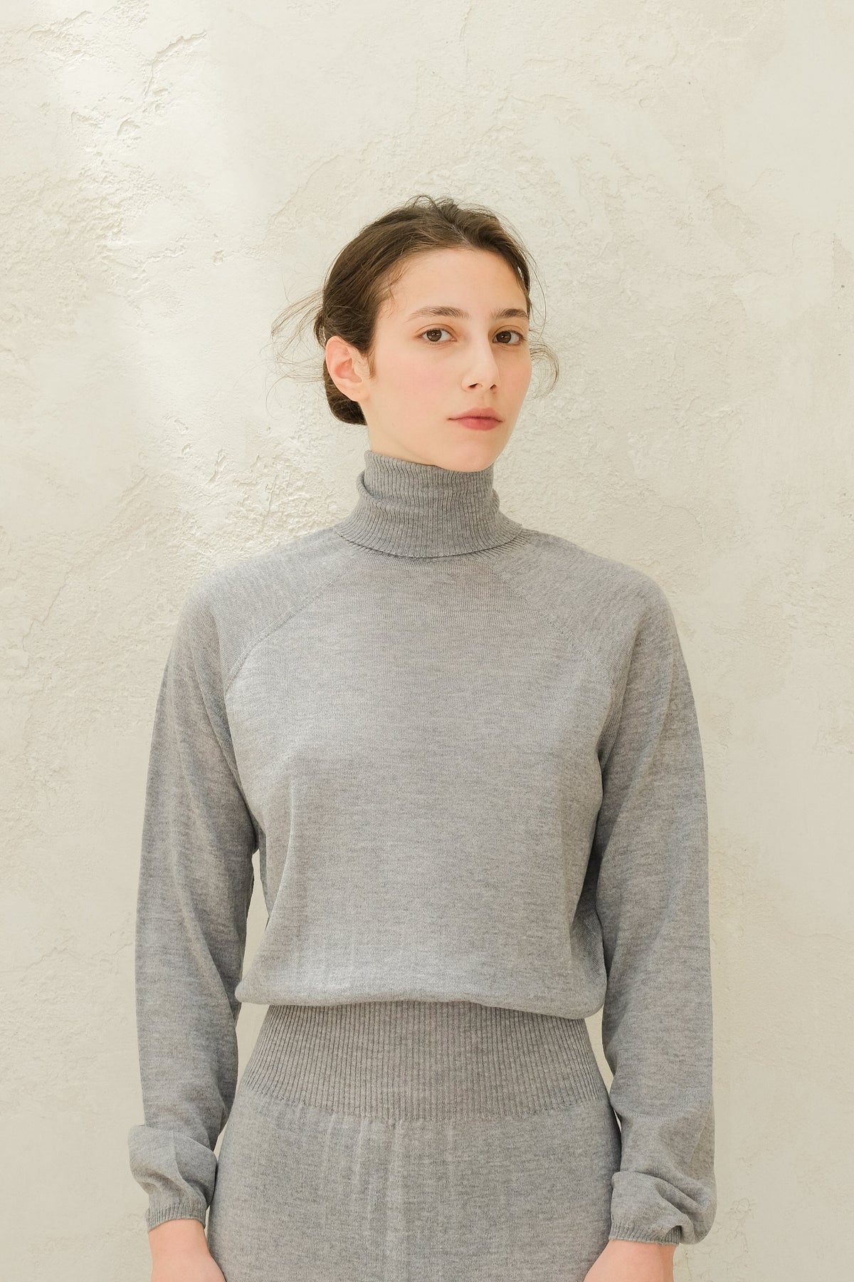 Close-up of lichtgrijs knit coltrui top with geribde tailleband and cuffs from the 3D-Knit Merino Wool set.
