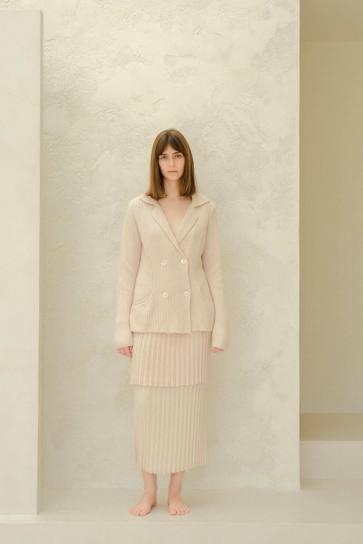 Mannequin porcognact a beige jupe longue plissée en coton fin with a matching double-breasted blazer en maille