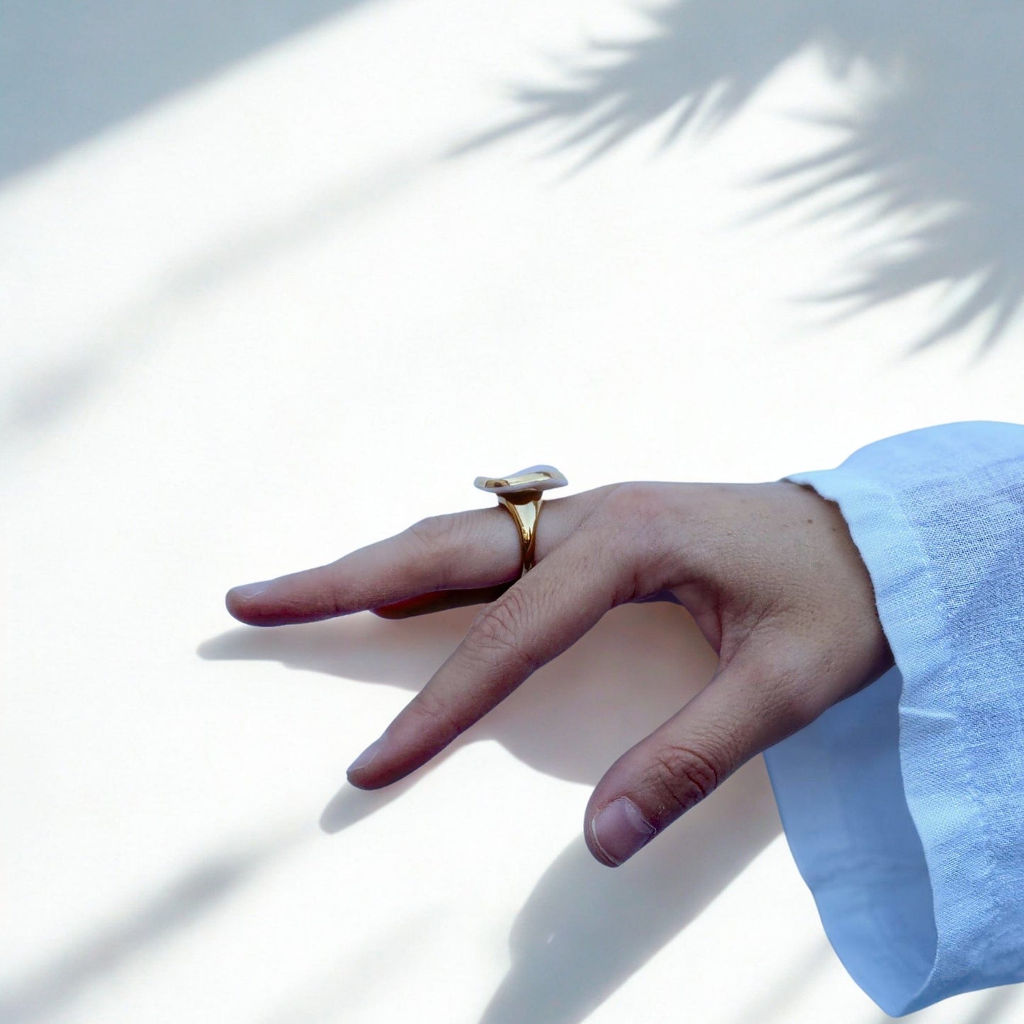 Leda pink handcrafted ceramic ring with gold luster worn on a finger