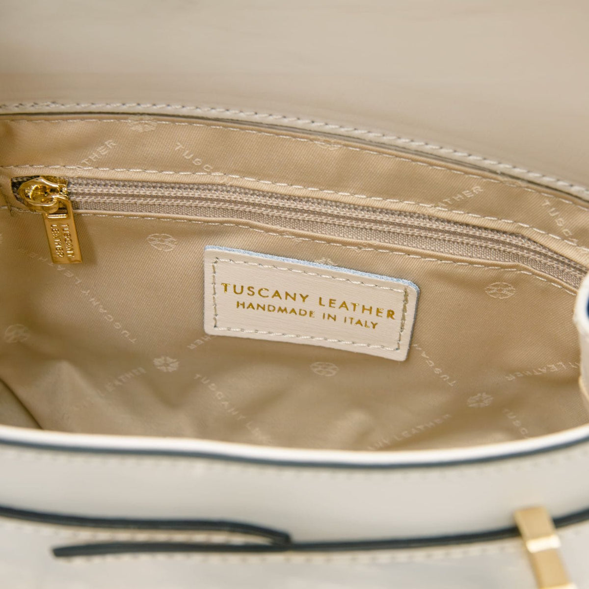 Interior of Maisy bag with beige lining, zip pocket, and Tuscany Leather handmade in Italy label.