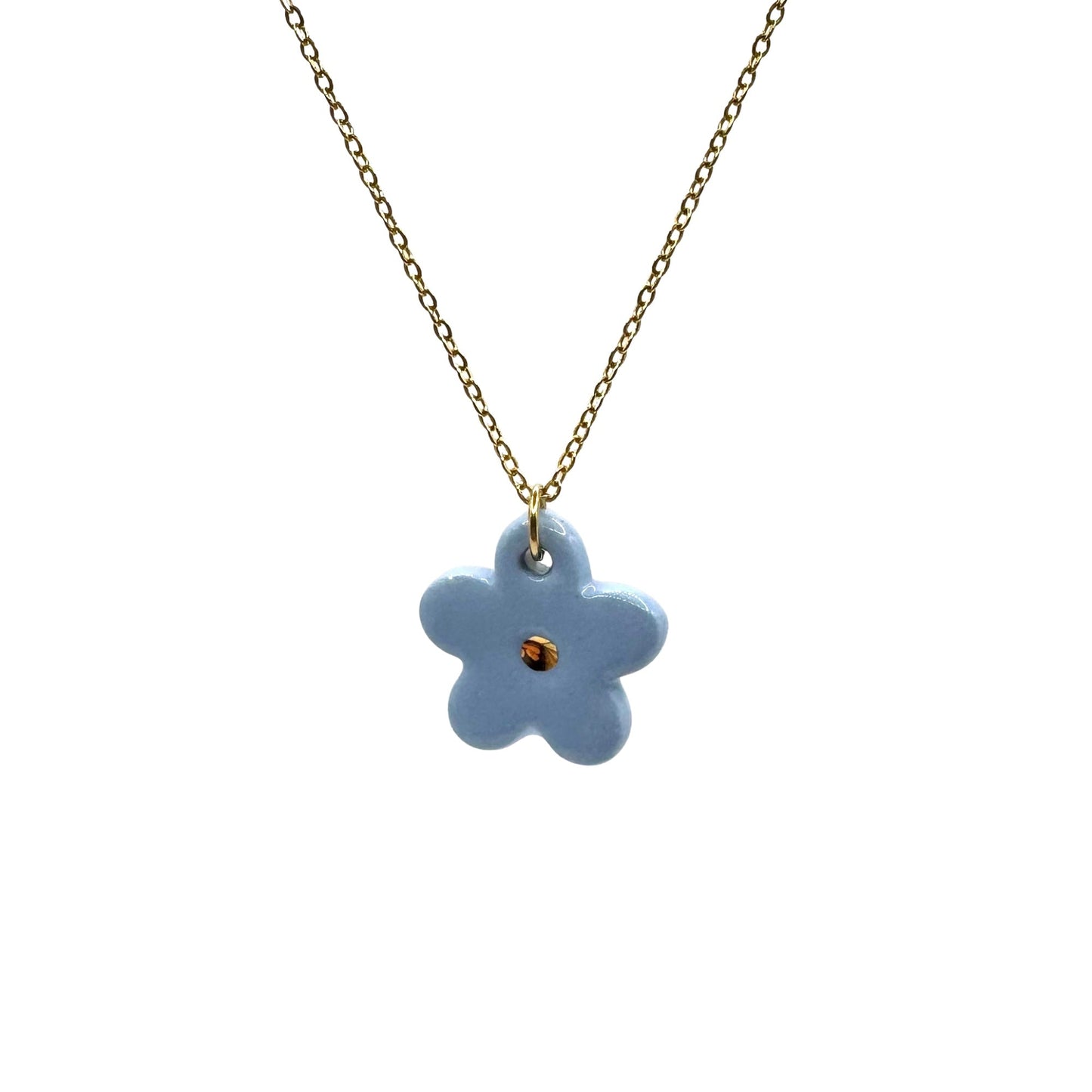 Blue flower ceramic pendant on a gold chain against a white background