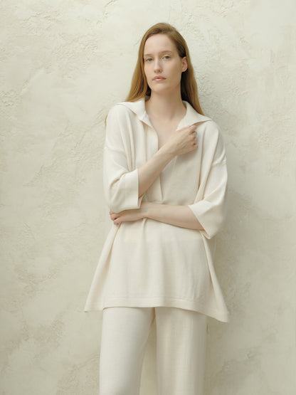 Front view of a woman in a cream Merino Wool Maxi Polo with a wide collar and relaxed fit