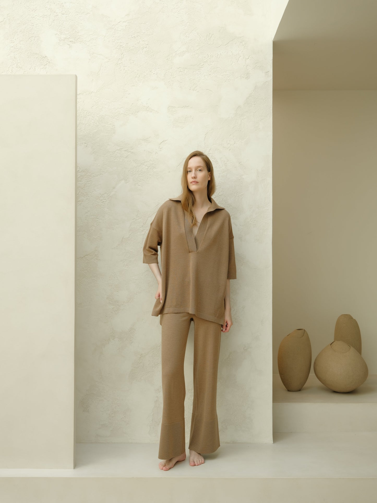 Model wearing taupe Extra Fine Merino Wool Maxi Polo set with an oversized top featuring three-quarter sleeves and wide-leg pants.