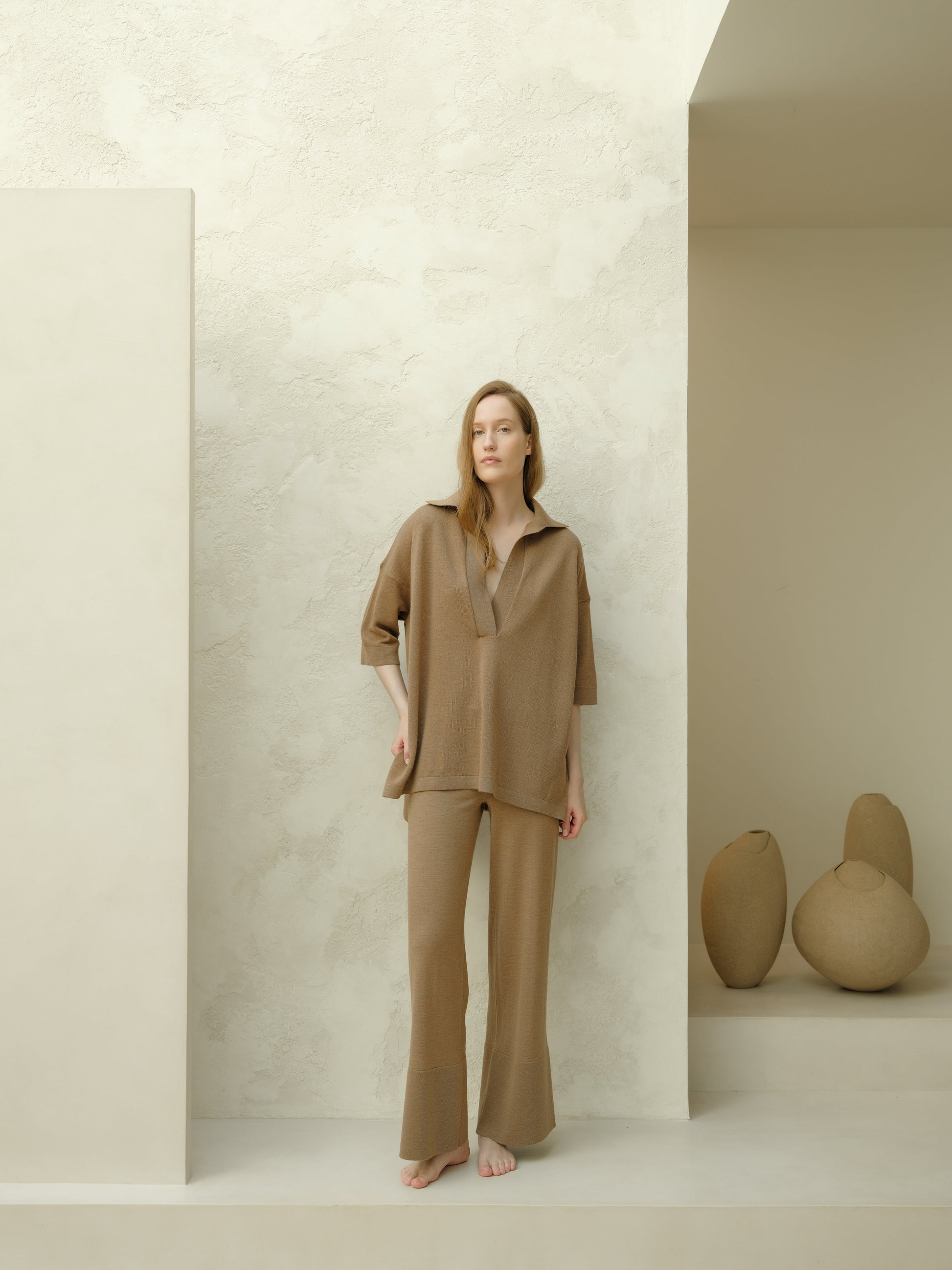 Model wearing taupe Extra Fine Merino Wool Maxi Polo set with an oversized top featuring three-quarter sleeves and wide-leg pants.