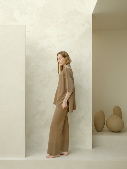 Side view of a model in taupe Extra Fine Merino Wool Maxi Polo set, loose top with three-quarter sleeves and matching wide pants.