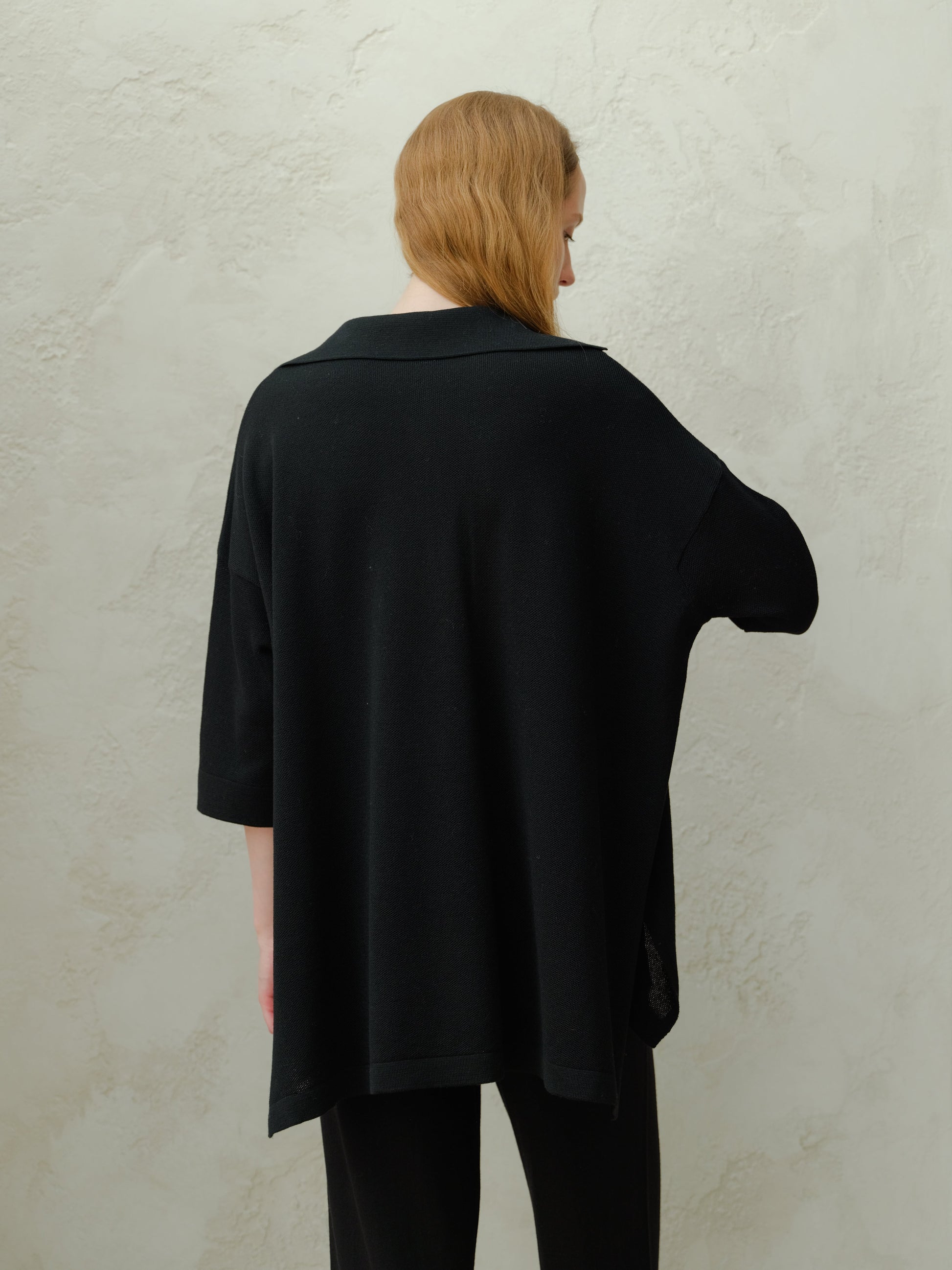 Back view of a model wearing a black Extra Fine Merino Wool Maxi Polo with a relaxed fit.