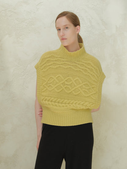 Front view of a model wearing a yellow cashmere mix maxi cable tunic with a high ribbed collar and bold cable patterns.