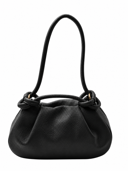 A black pebbled leather shoulder bag with a single integrated handle, featuring a gathered, slouchy silhouette and decorative knot-like detailing at the base of the handle, shown on a plain white background.