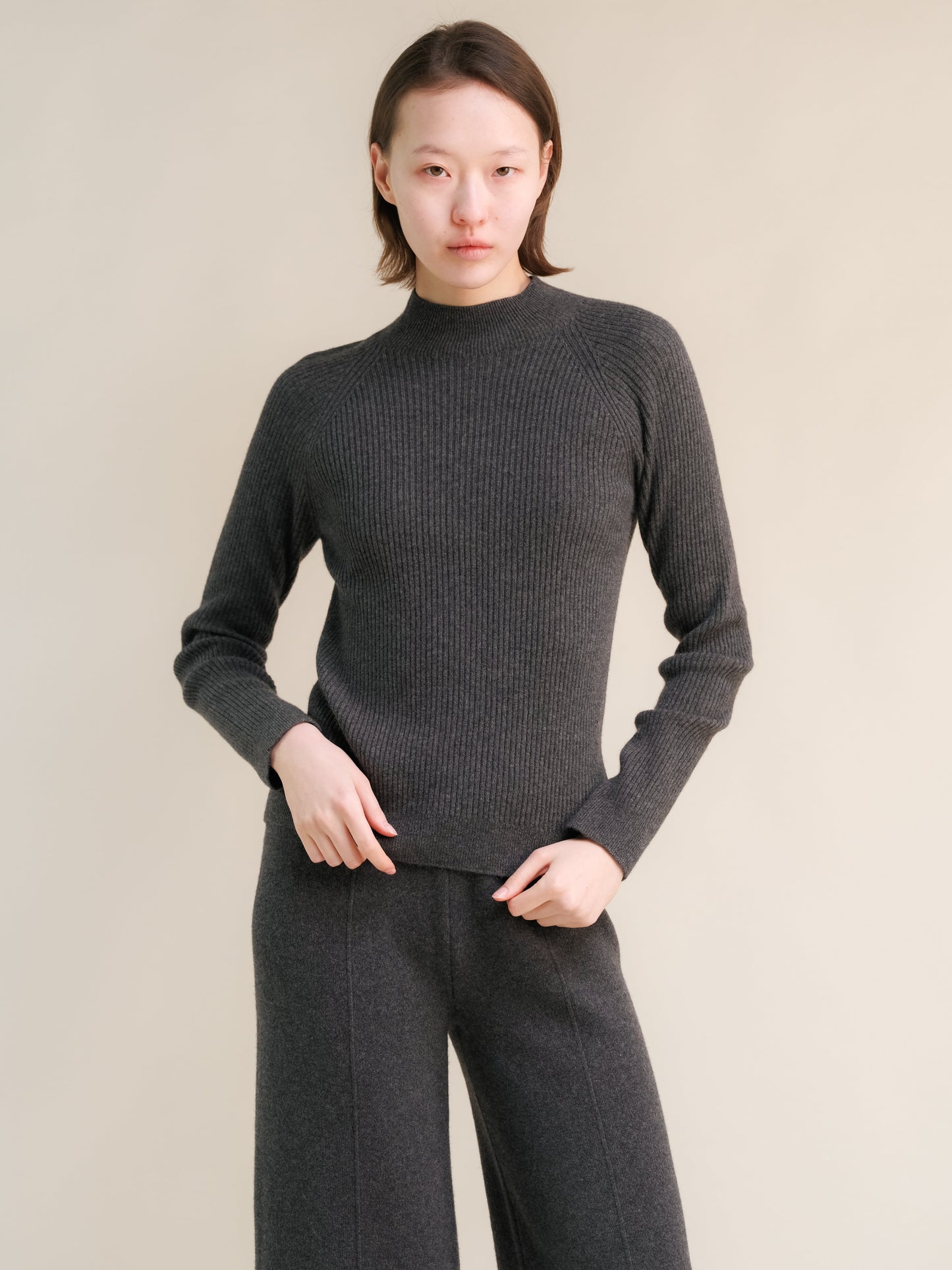 Dark gray ribbed cashmere mix 3D knit mock neck sweater on a model