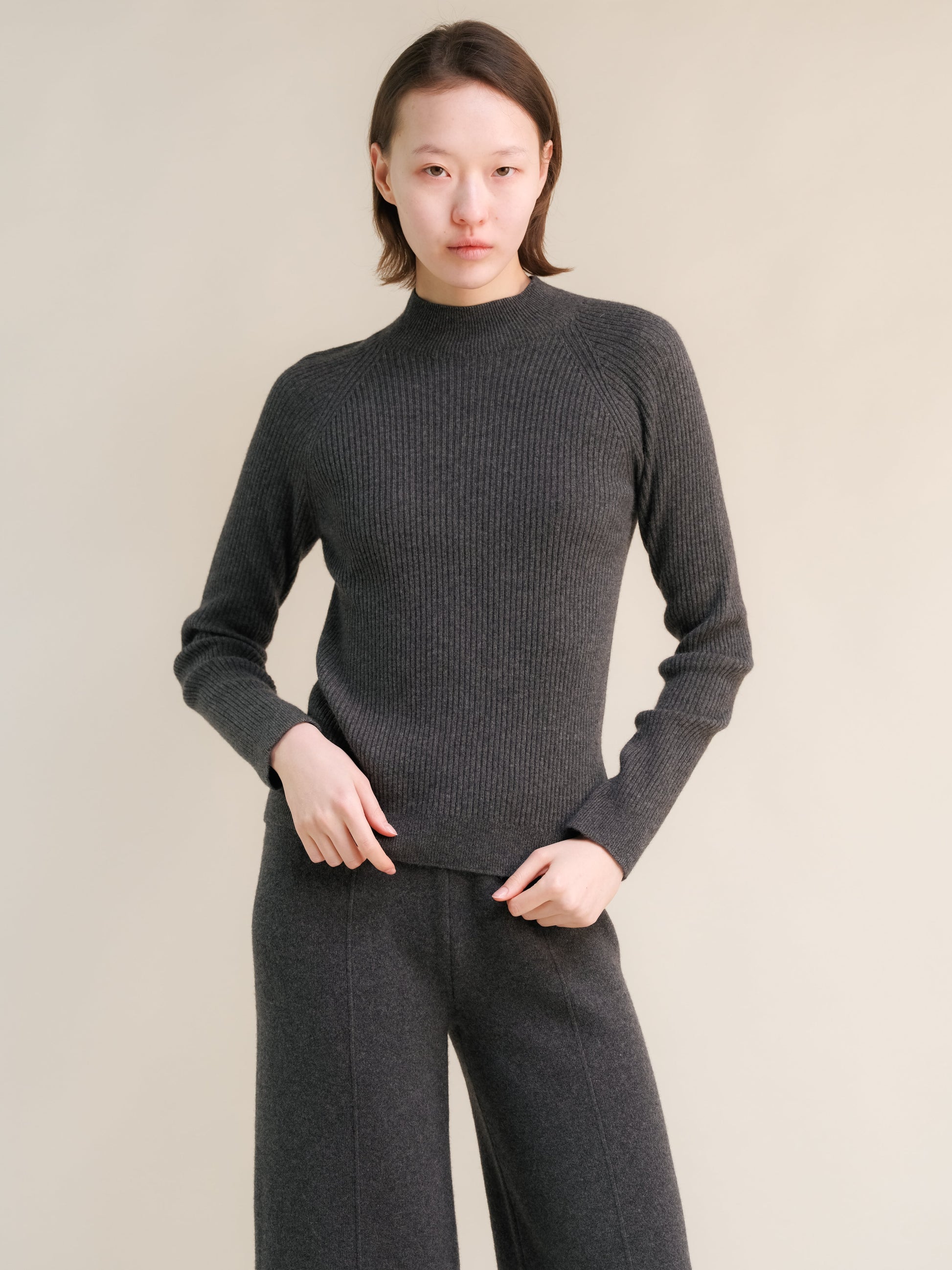 Dark gray ribbed cashmere mix 3D knit mock neck sweater on a model