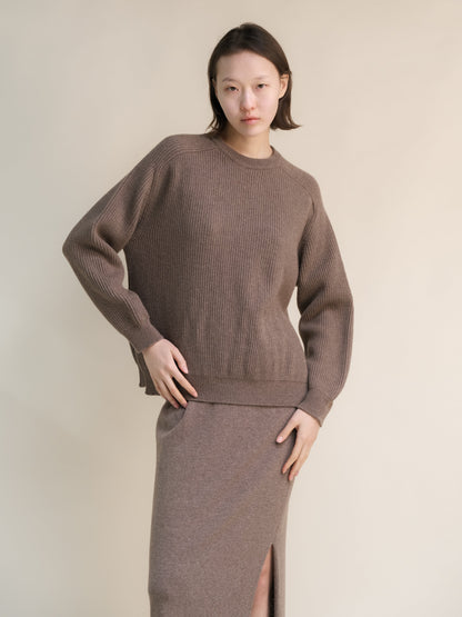 Model wearing a brown cashmere mix crewneck ribbed sweater with a relaxed fit and side slits.