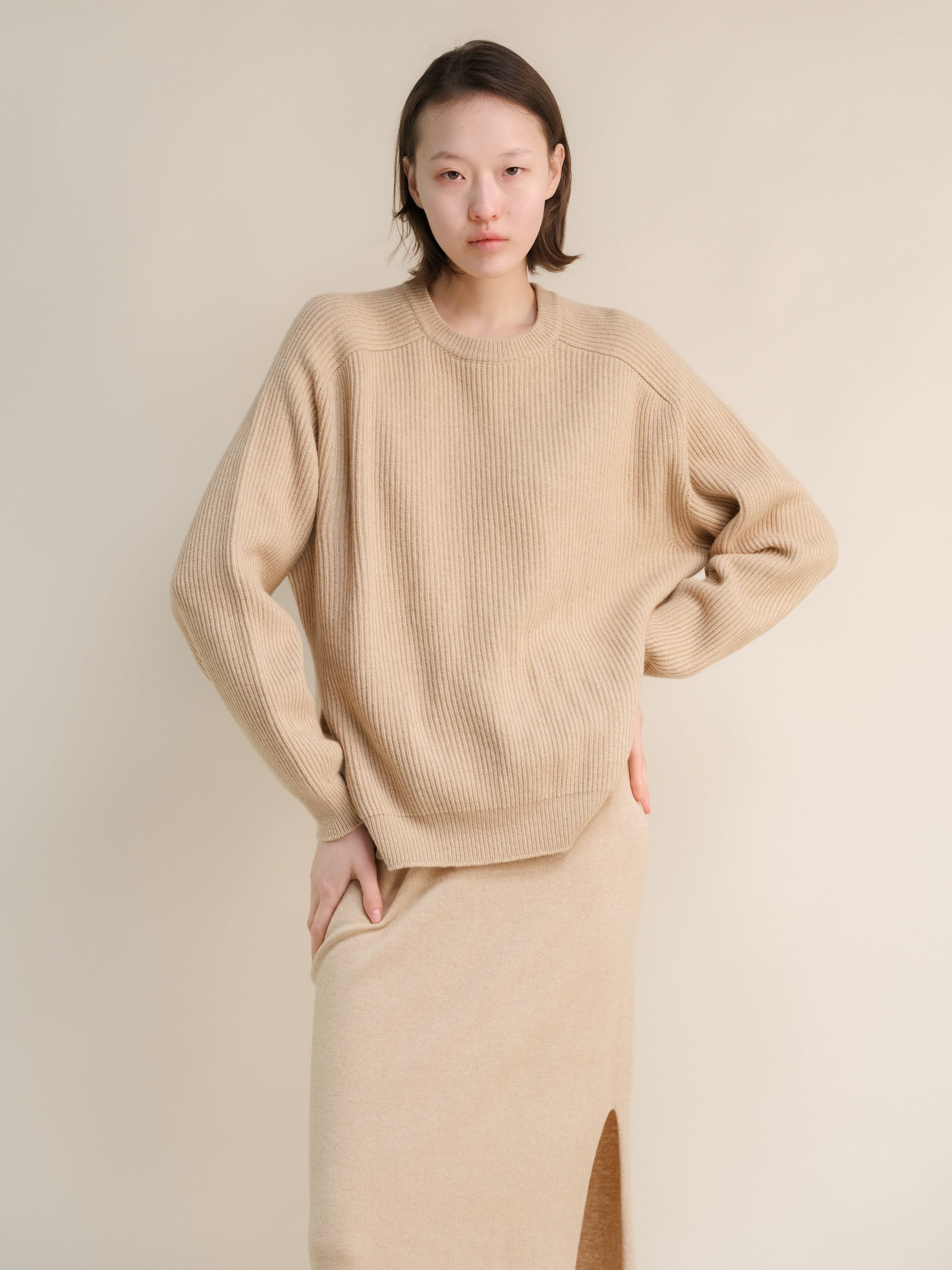 Beige cashmere mix crewneck ribbed sweater worn by a model in a relaxed oversized fit
