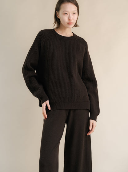 Model wearing a dark brown ribbed cashmere mix crewneck sweater with a relaxed fit