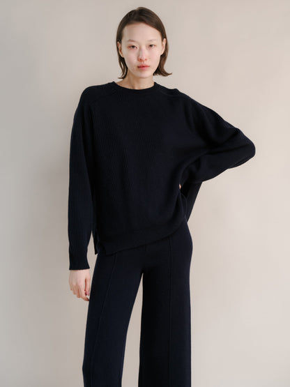 Model wearing navy cashmere mix crewneck ribbed sweater with lateral slits