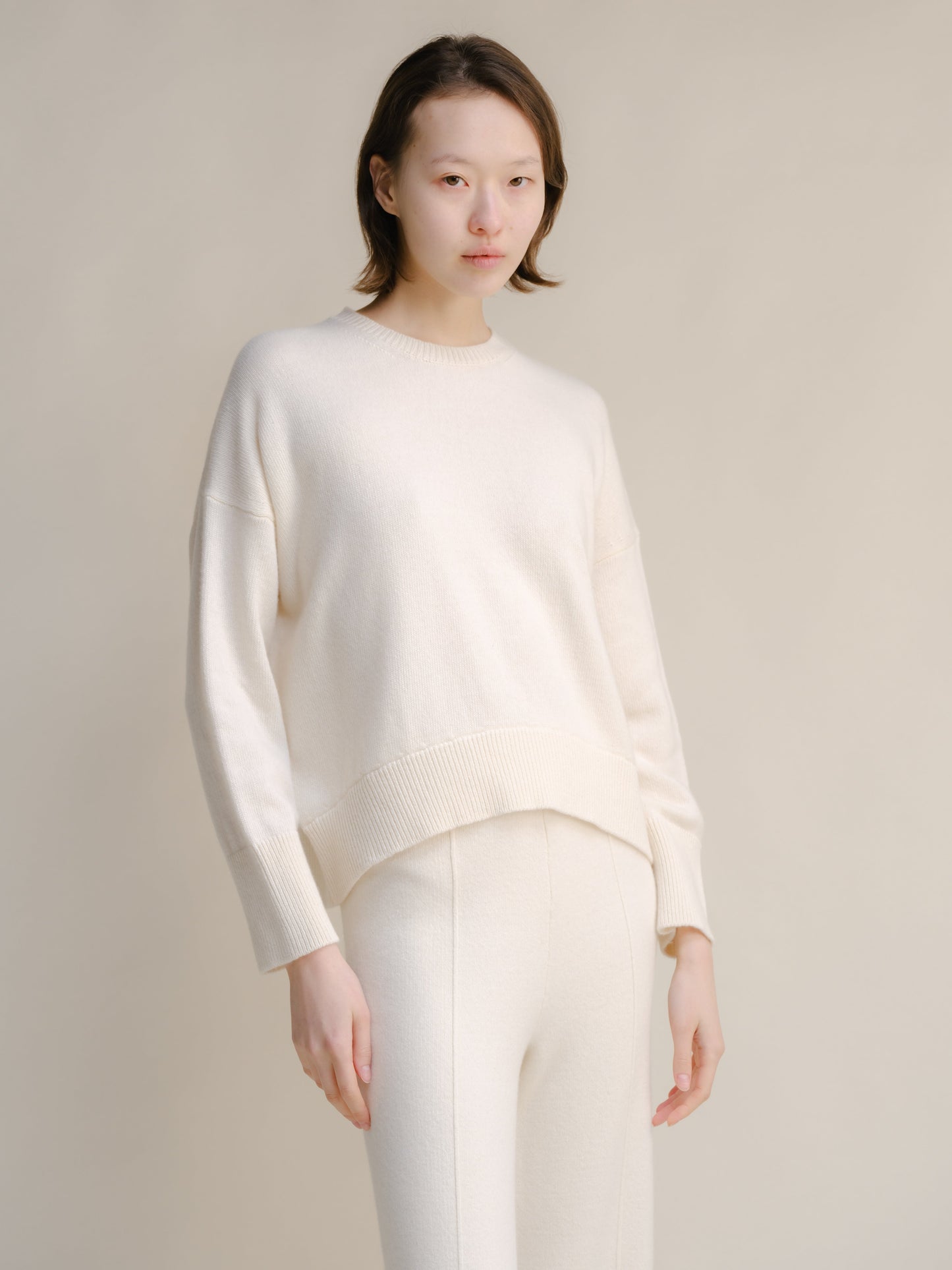 Model wearing white cashmere mix crewneck sweater, front view