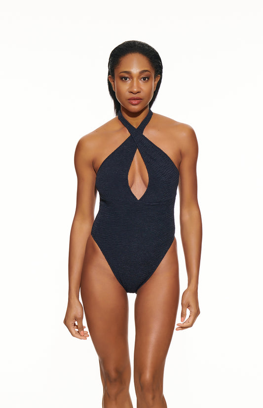 Woman wearing a black halter neck swimsuit on a white background