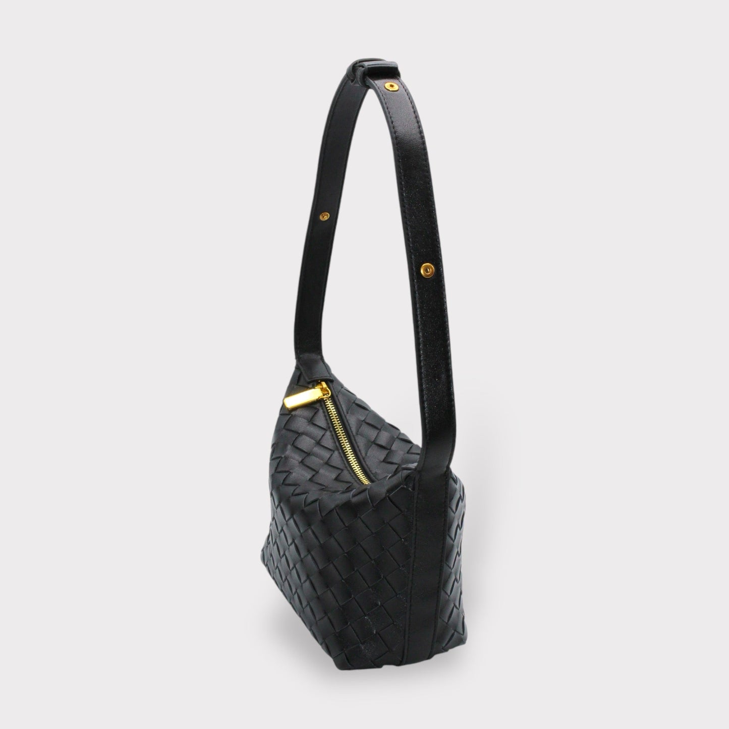 Side view of black woven leather box pouch with a long strap and goldfarbene Beschläge