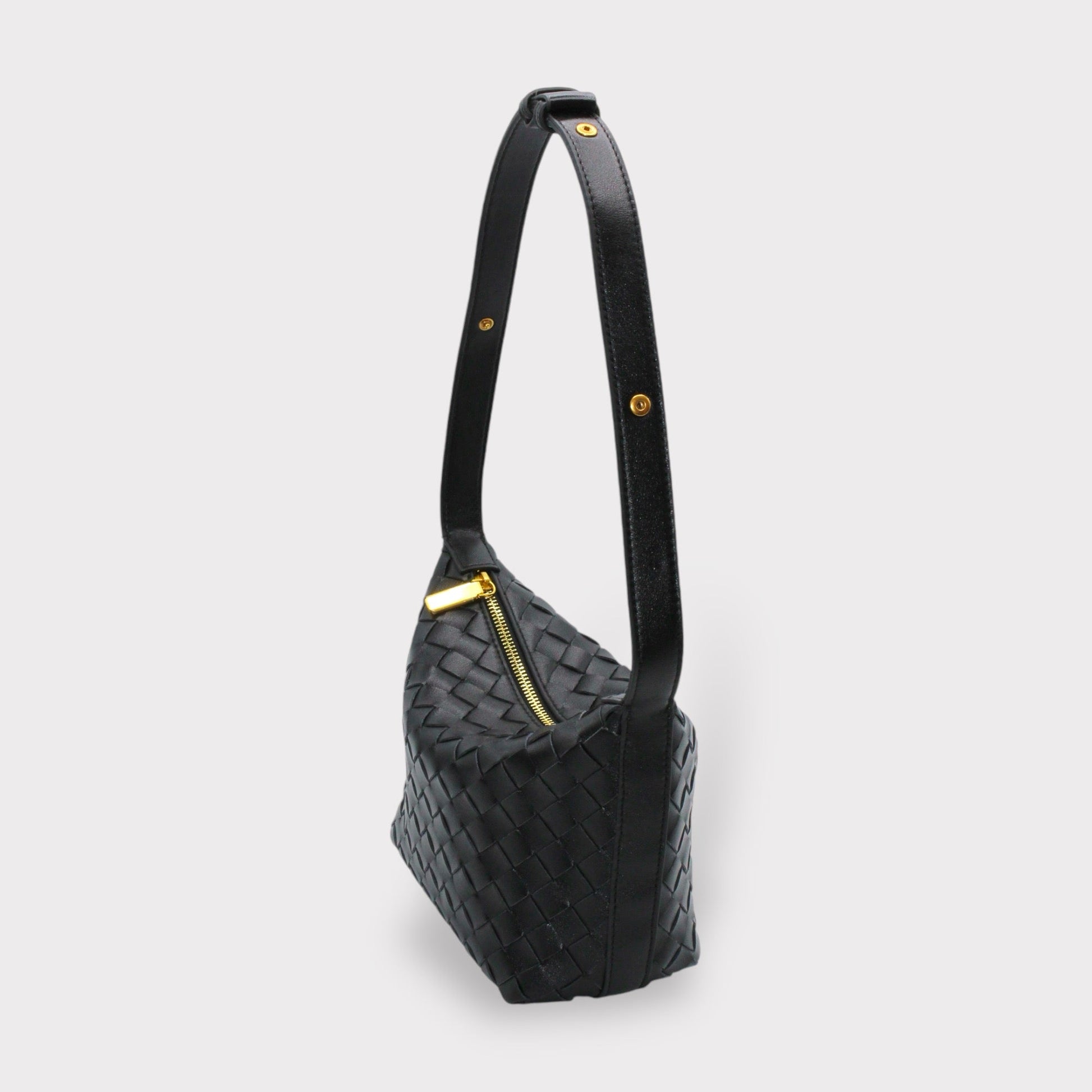 Side view of black woven leather box pouch with a long strap and goldfarbene Beschläge