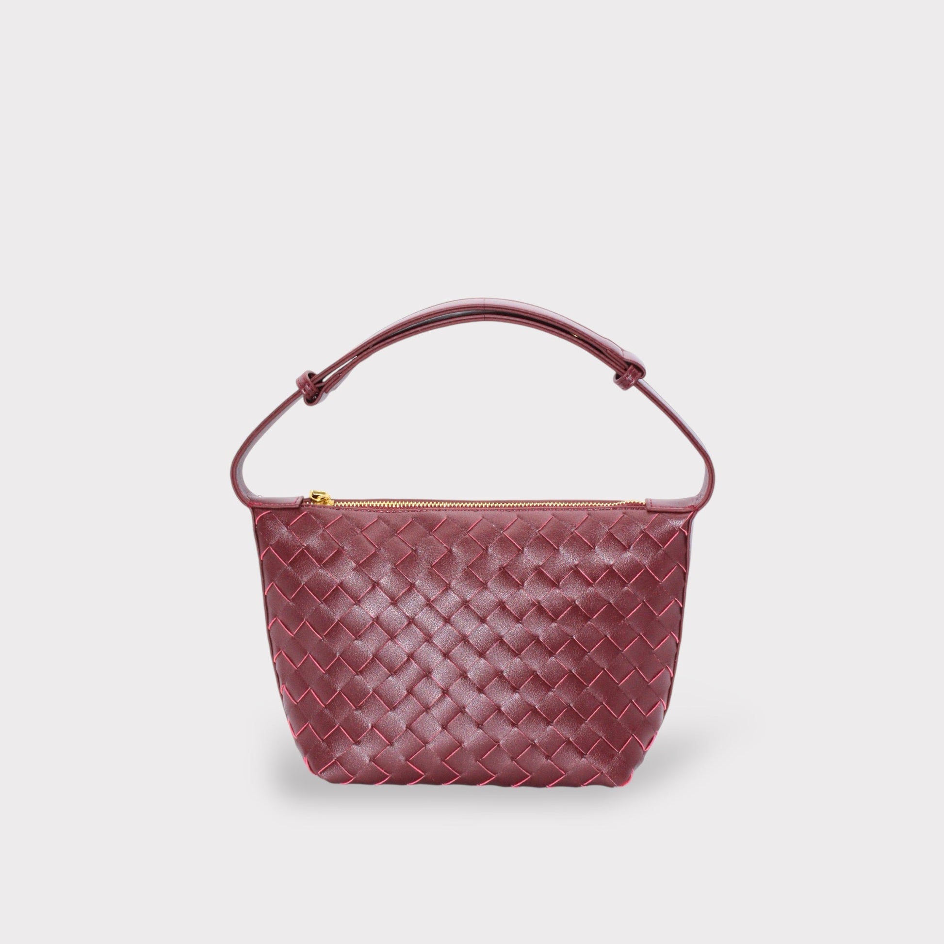 Wine burgundy woven leather boxed pouch bag with an arched Tragegriff and gold zipper.