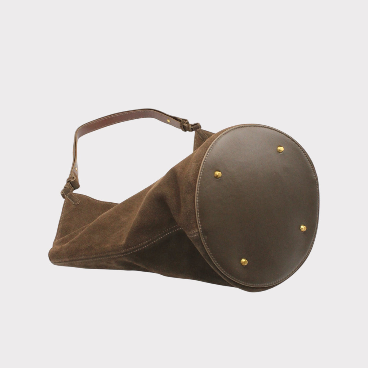 Vista laterale della borsa tote Elsa in camoscio con fondo arrotondato e tracolla marrone