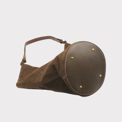 Vista laterale della borsa tote Elsa in camoscio con fondo arrotondato e tracolla marrone