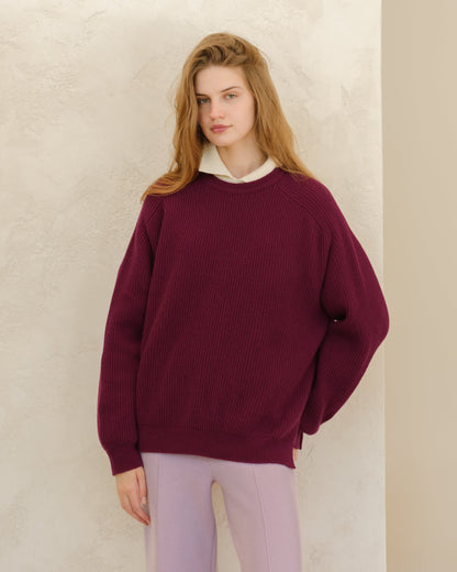 Model wearing burgundy Cashmere Mix Crewneck Ribbed Sweater with Lateral Slits and a white collar peeking out against a light textured wall.