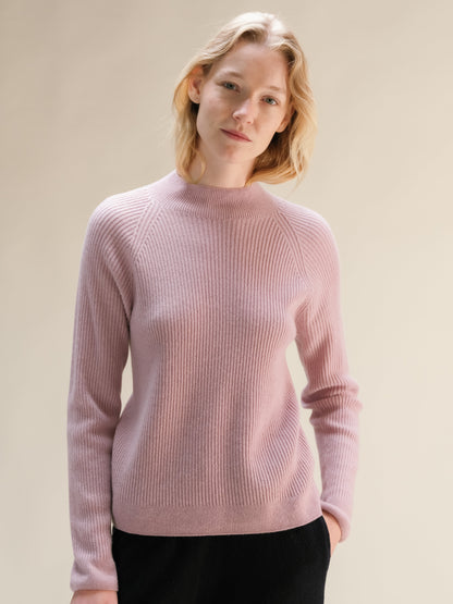 Soft pink cashmere mix ribbed mock neck sweater on a model.
