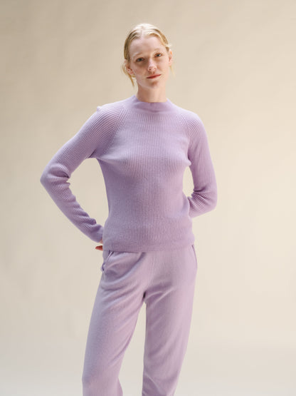 Woman wearing a lilac ribbed mock neck sweater with matching knit pants