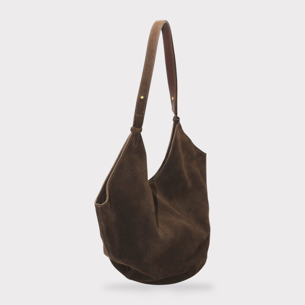 Elsa suede leather boat tote con circular leather base e long tracolla regolabile su sfondo bianco.