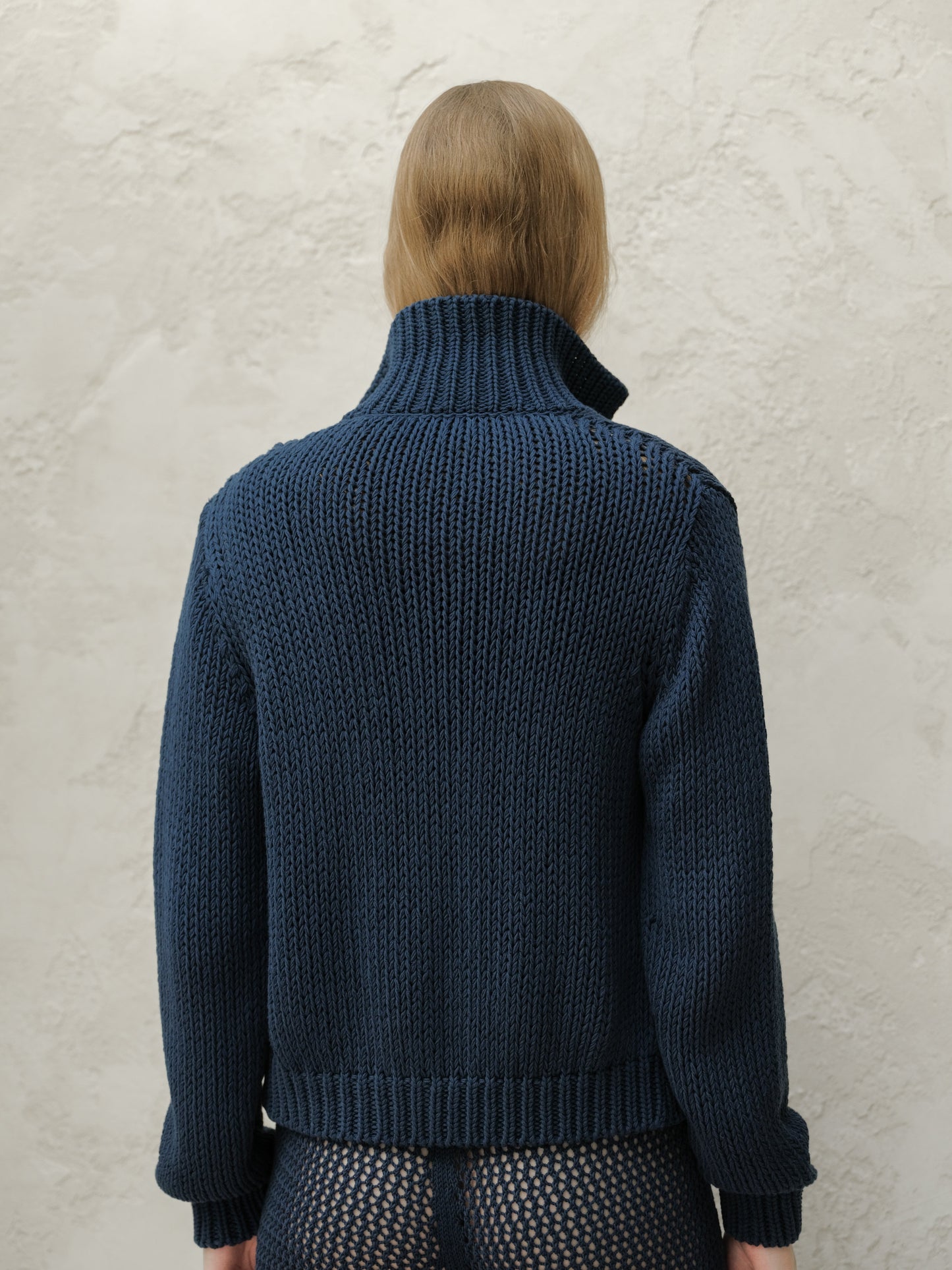 Back view of a model in a navy Fine Cotton Bomber Jacket with a tall ribbed collar