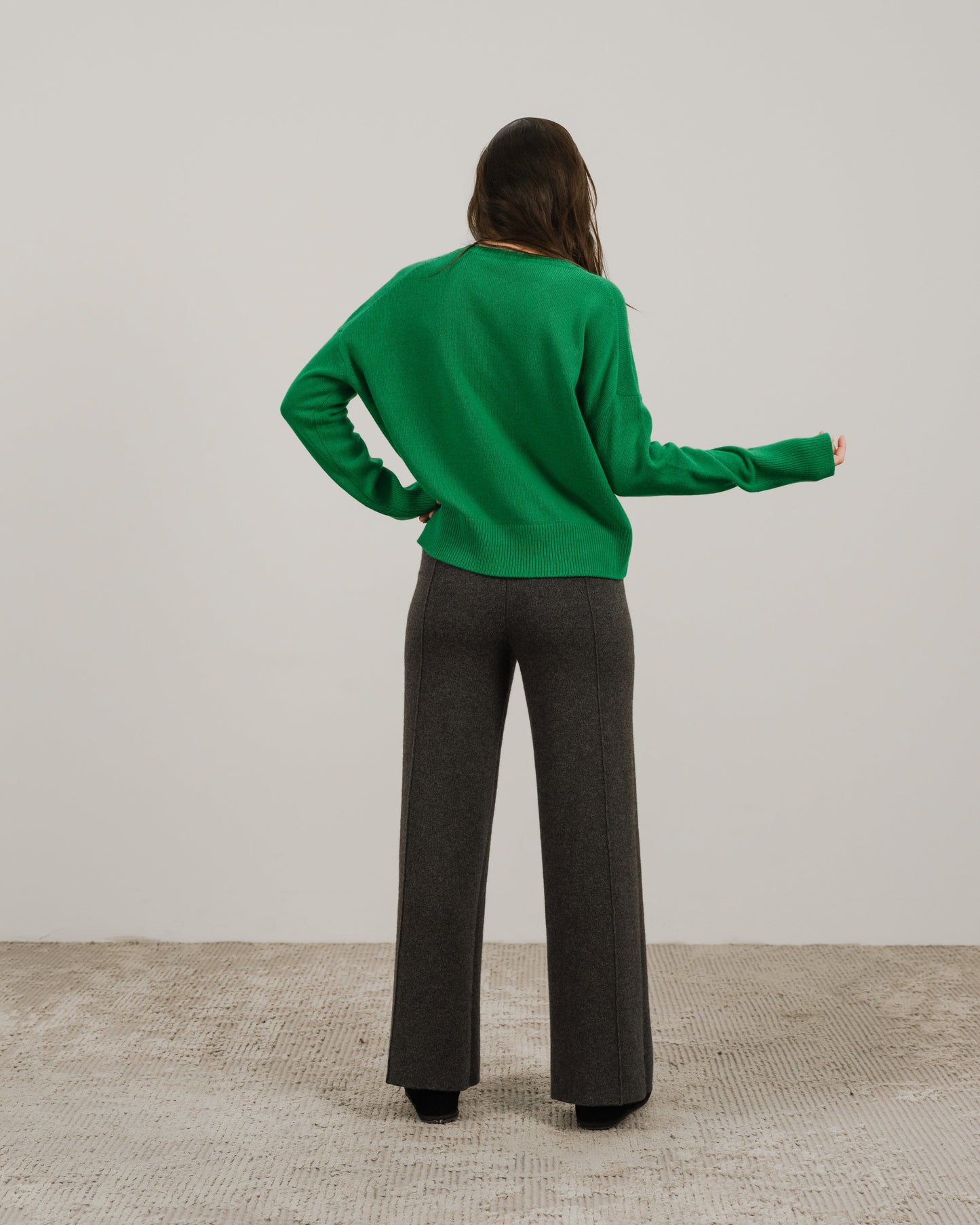 Back view of a person wearing a bright green cashmere mix crewneck sweater