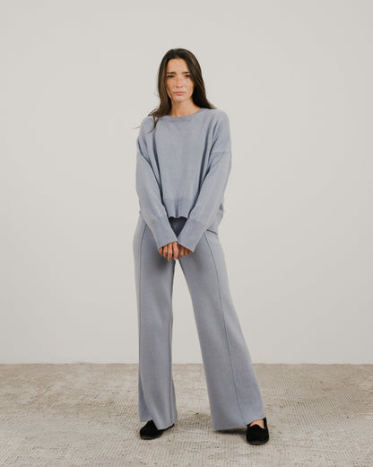 Full-body front view of a model wearing a light blue cashmere mix crewneck sweater with matching wide-leg pants