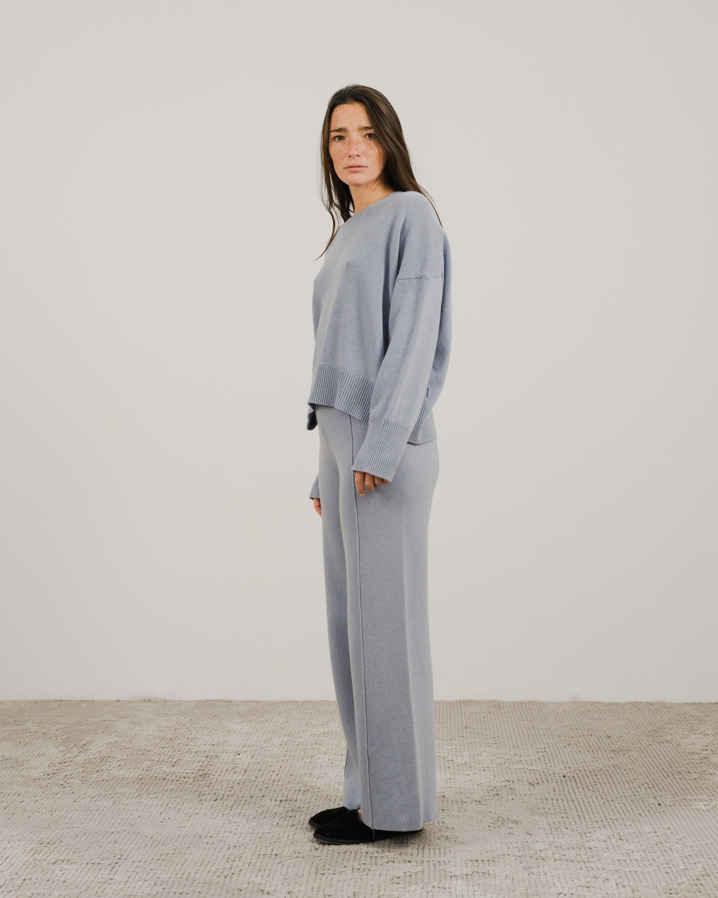 Light blue oversized cashmere mix crewneck sweater worn by a model in a side pose.
