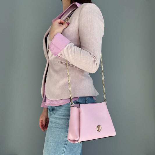 Pink leather Abby shoulder bag with gold chain strap worn crossbody.