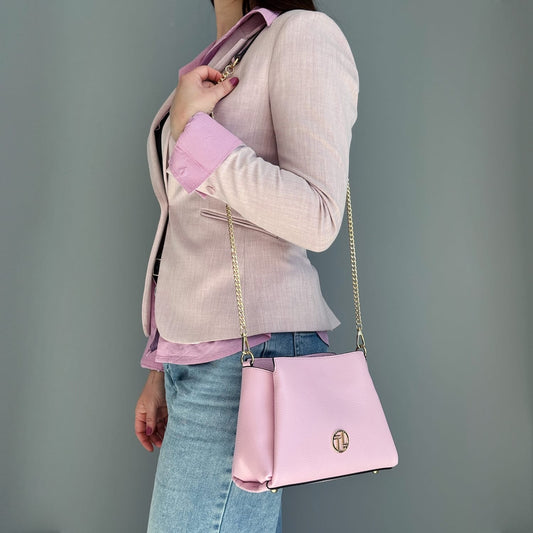 Pink leather Abby shoulder bag with gold chain strap worn crossbody.