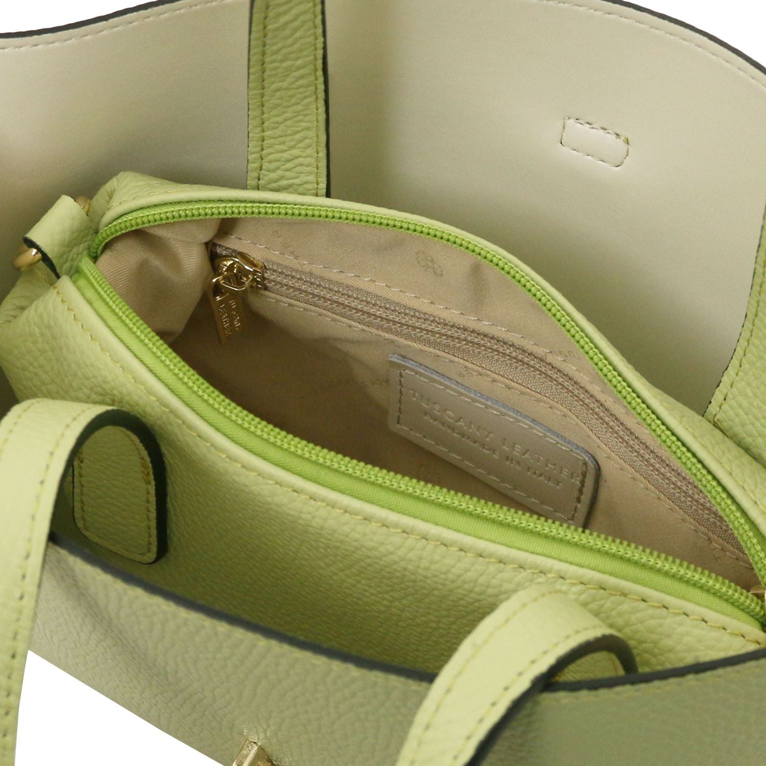 Interior top view of lime tote showing a zip pocket and an inner label