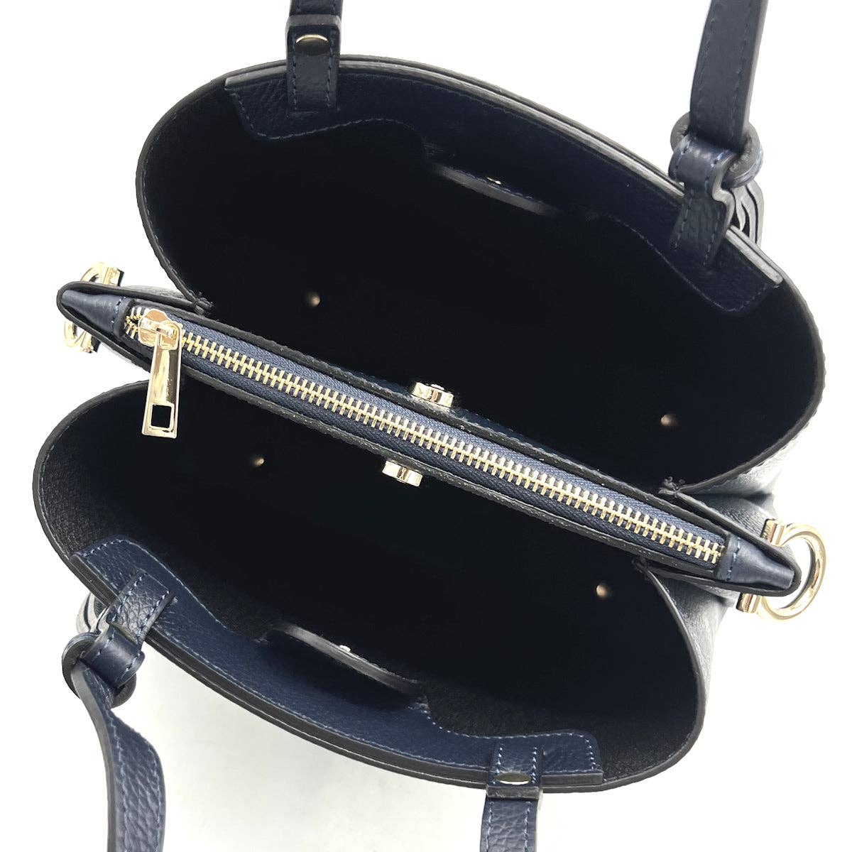 Navy blue handbag with gold zipper on a white background
