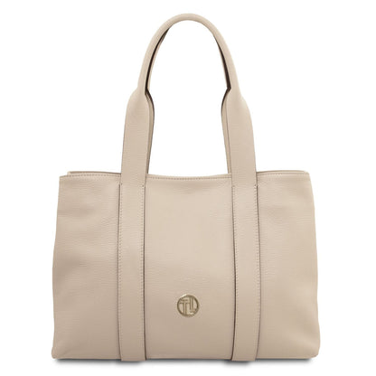 Beige soft leather shoulder bag with two handles and a small gold logo emblem on the front
