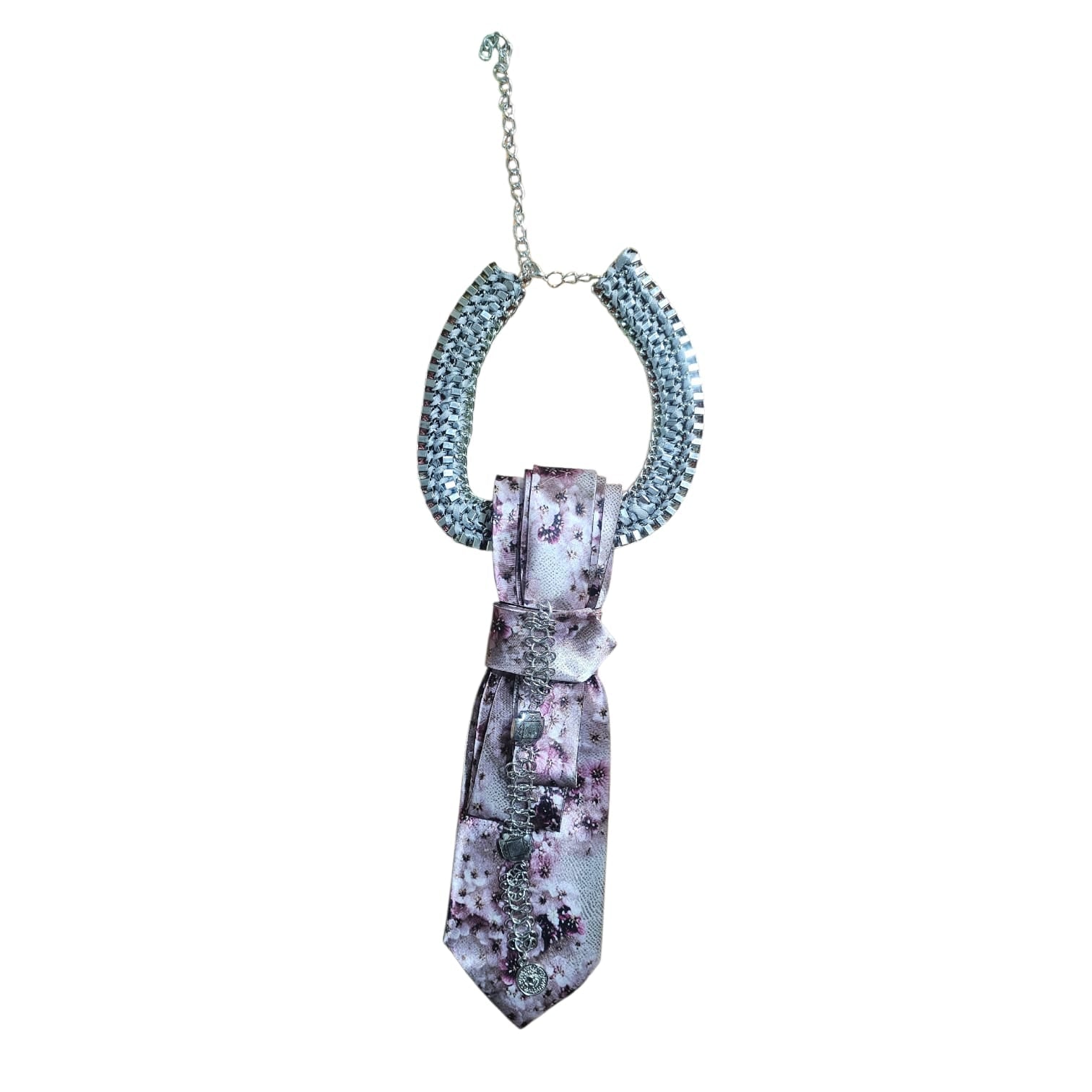 Close-up of pink floral silk tie with bow and dangling chains on a display bust.