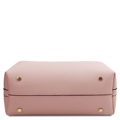 Bottom view of soft pink pebbled leather bucket bag with gold feet.