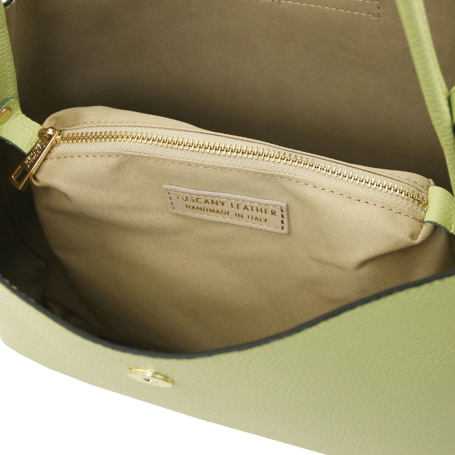 Inside view of lime Clio bucket bag showing beige lining and a gold zip pocket with Tuscany Leather label
