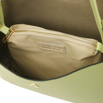 Inside view of lime Clio bucket bag showing beige lining and a gold zip pocket with Tuscany Leather label